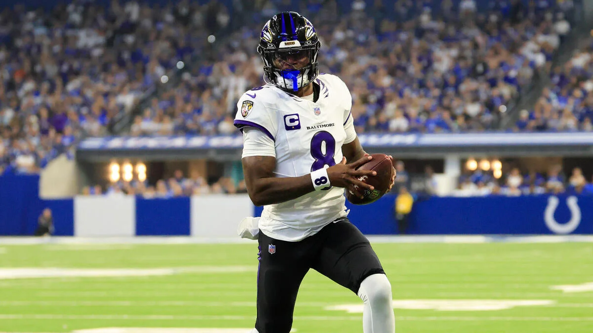 Baltimore Ravens quarterback in uniform runs with the football during a game.