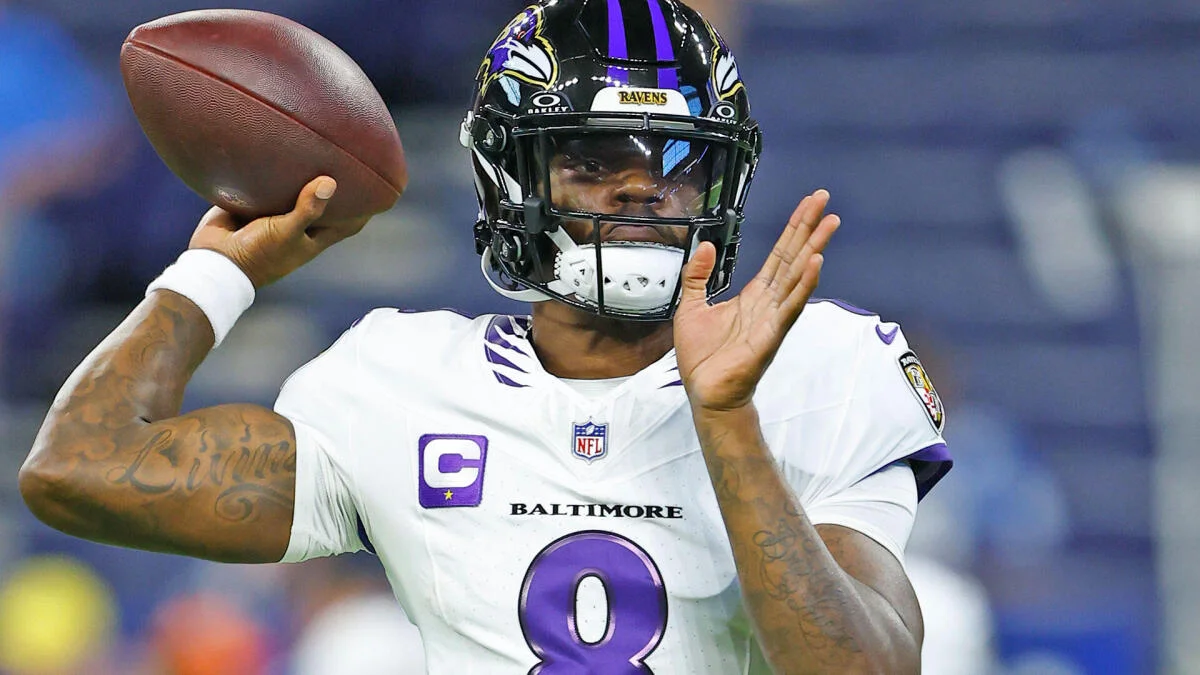 Baltimore Ravens quarterback in white uniform prepares to throw a football during a game