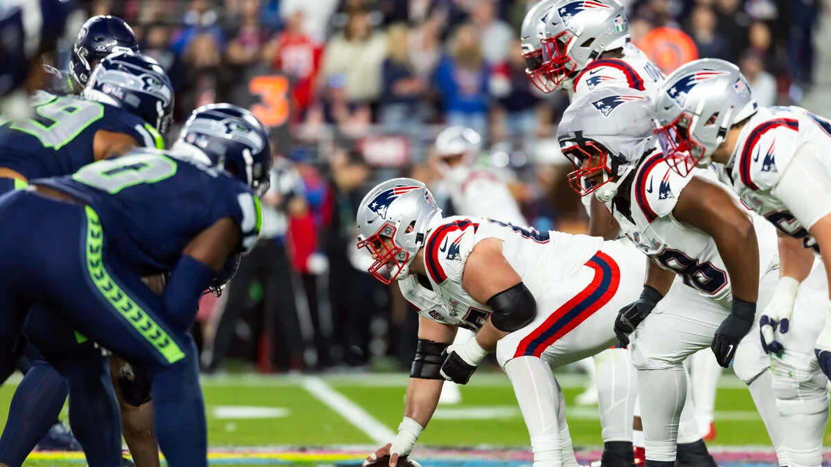 Seattle Seahawks and New England Patriots players line up before a football play