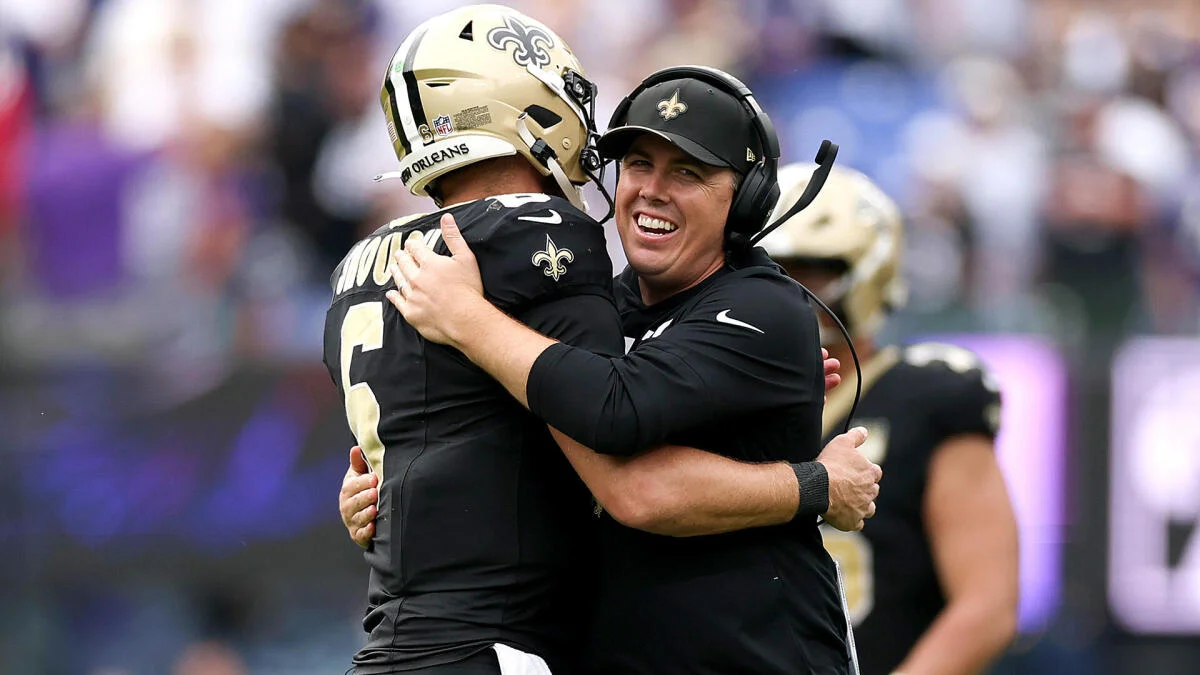 New Orleans Saints player and coach embrace on the sideline during an NFL game
