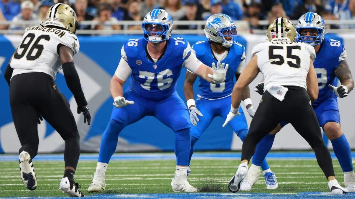 Detroit Lions players in blue block New Orleans Saints defenders in white during an NFL game