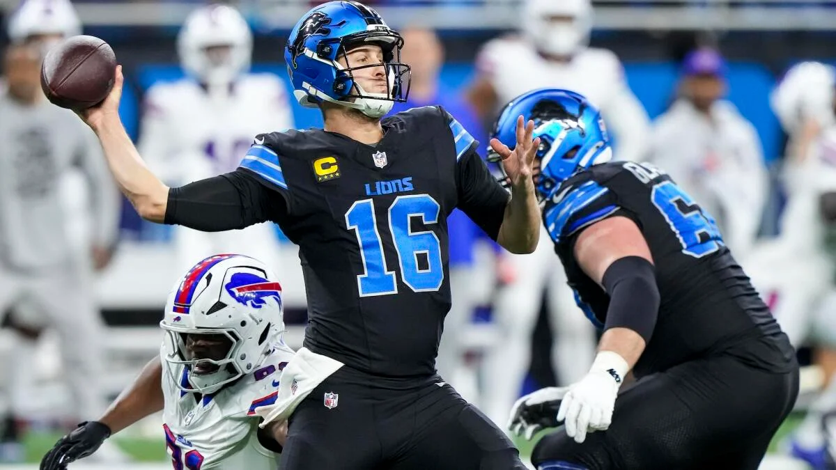Detroit Lions quarterback throws a football as players block during an NFL game.