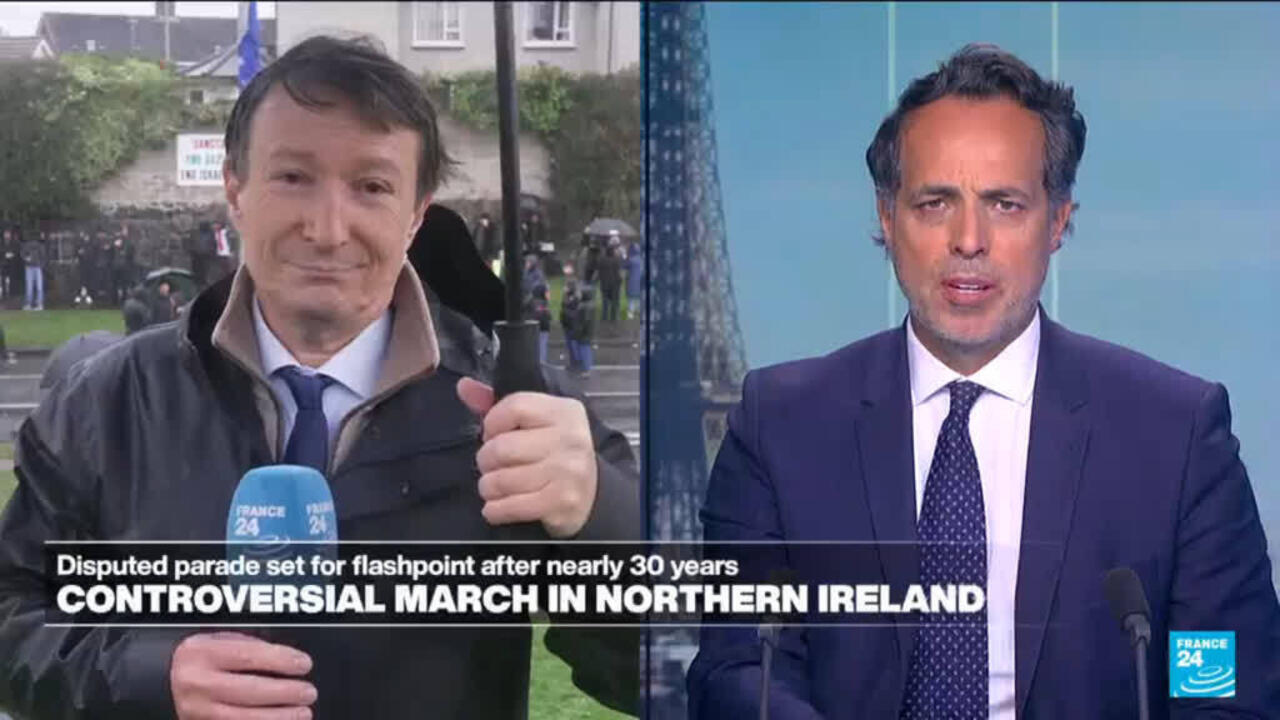 Split-screen news broadcast shows a man reporting outdoors beside a studio presenter in a suit.
