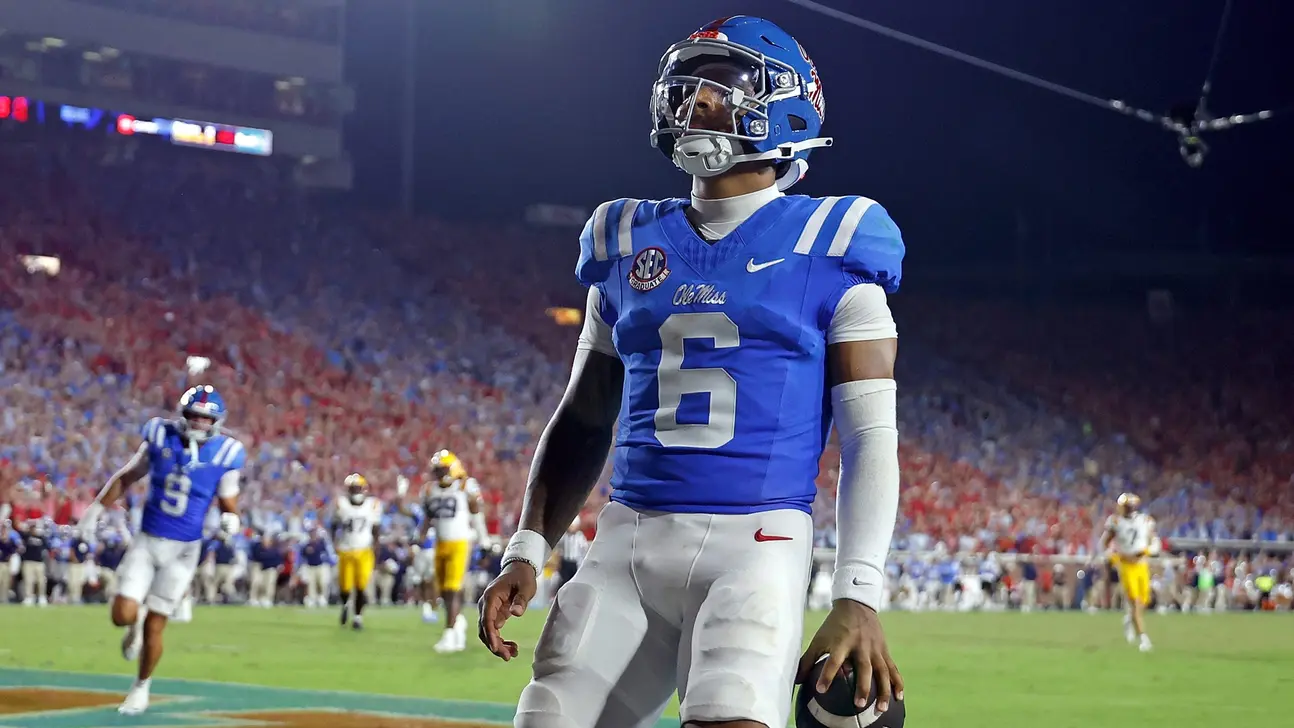 Ole Miss player wearing number 6 stands on the field with a football during a game.