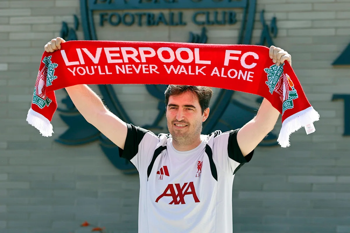 Man in Liverpool shirt holding a red Liverpool FC scarf above his head