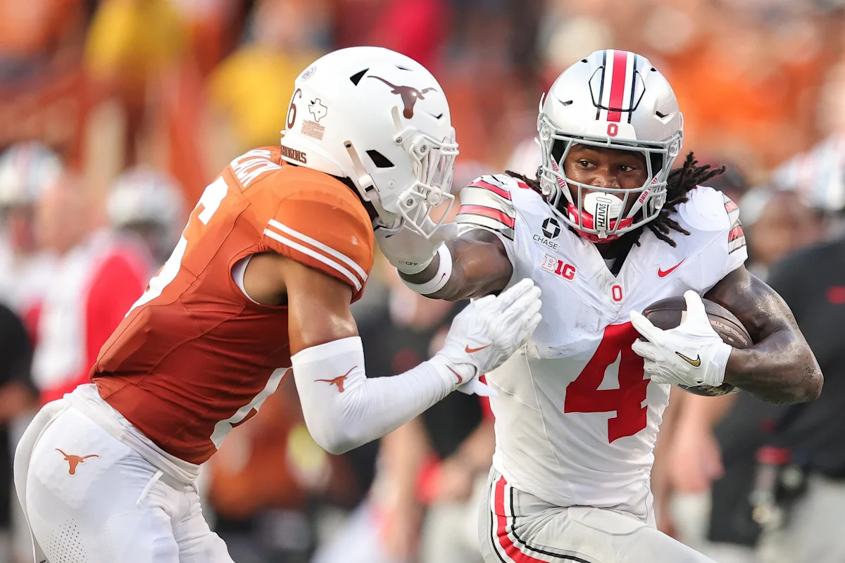 Ohio State ball carrier runs past a Texas defender during a football game.