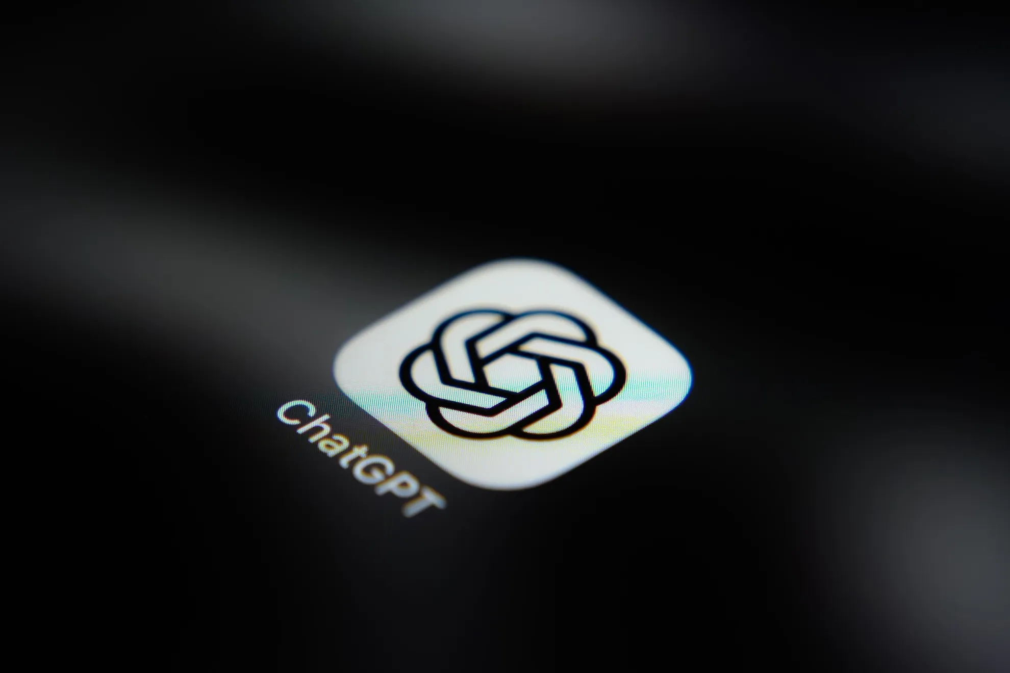 Close-up of the ChatGPT app icon and label on a dark screen.