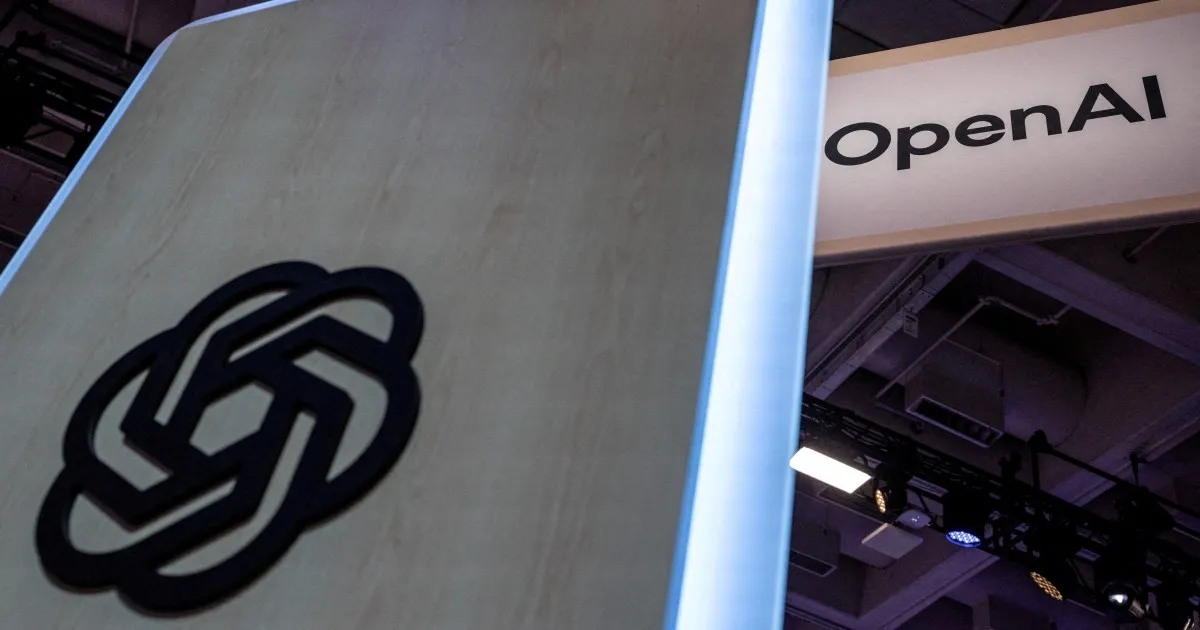 OpenAI knot logo on a display panel beside an OpenAI sign at an indoor event.