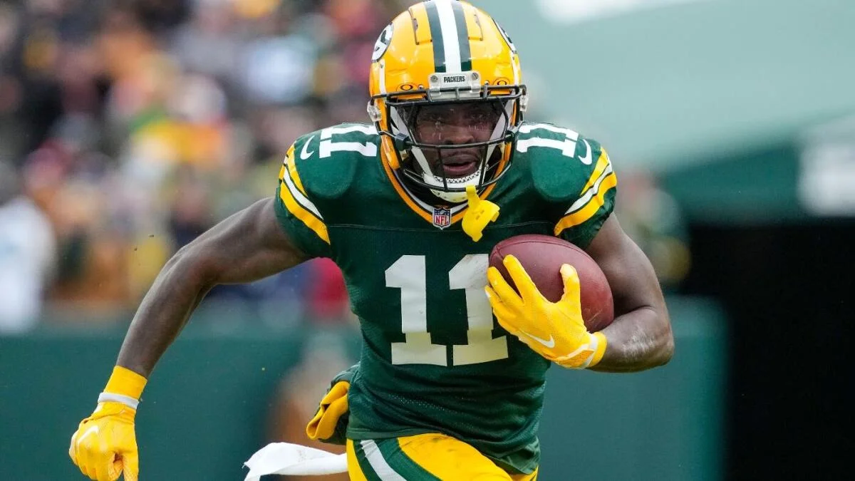 A Green Bay Packers player in a number 11 jersey runs with the football.