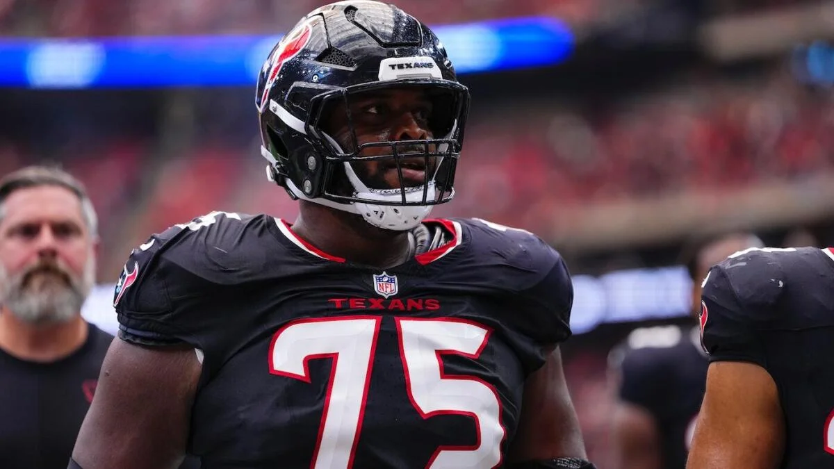 Houston Texans player wearing number 75 stands on the sideline in a helmet and uniform.