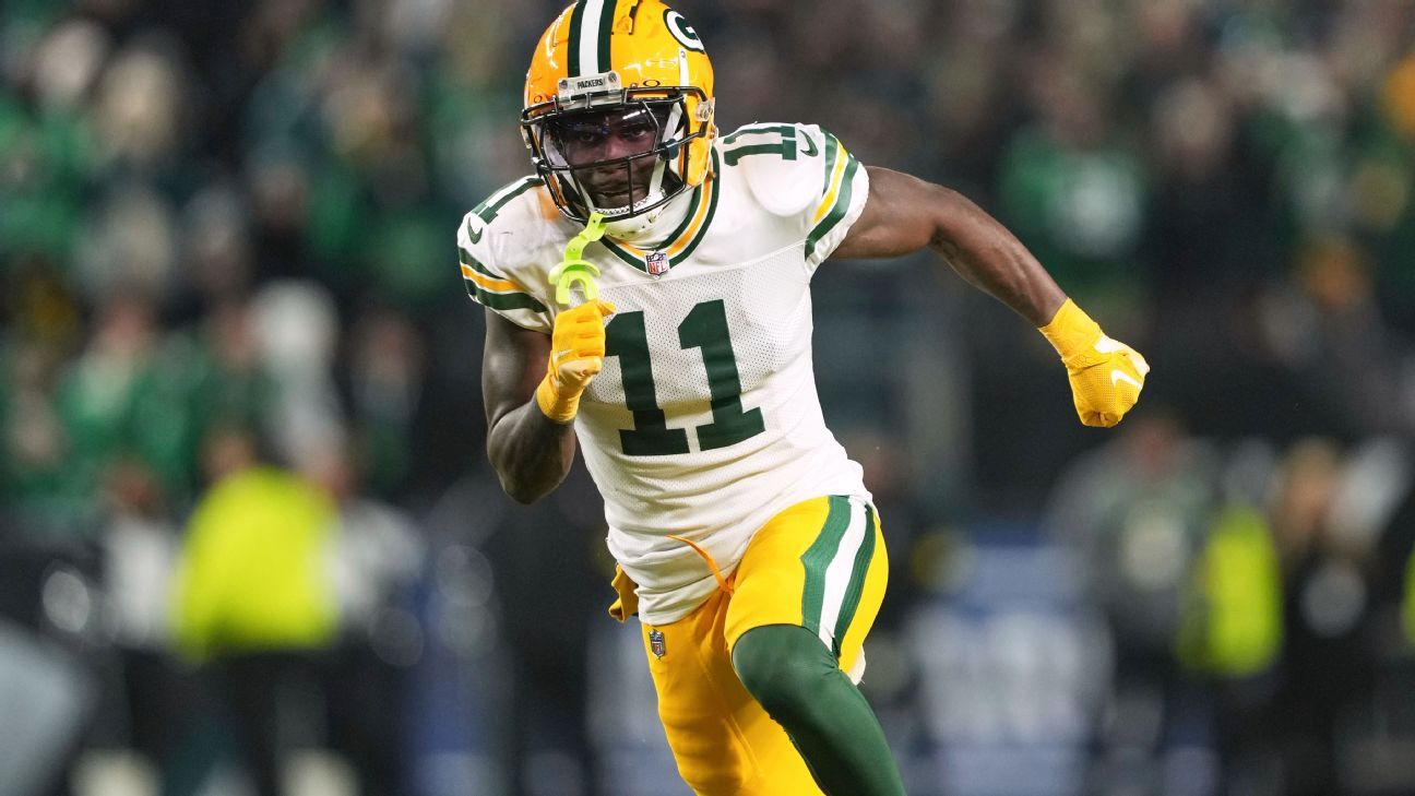 Packers player in a white number 11 jersey runs with the ball during a game.