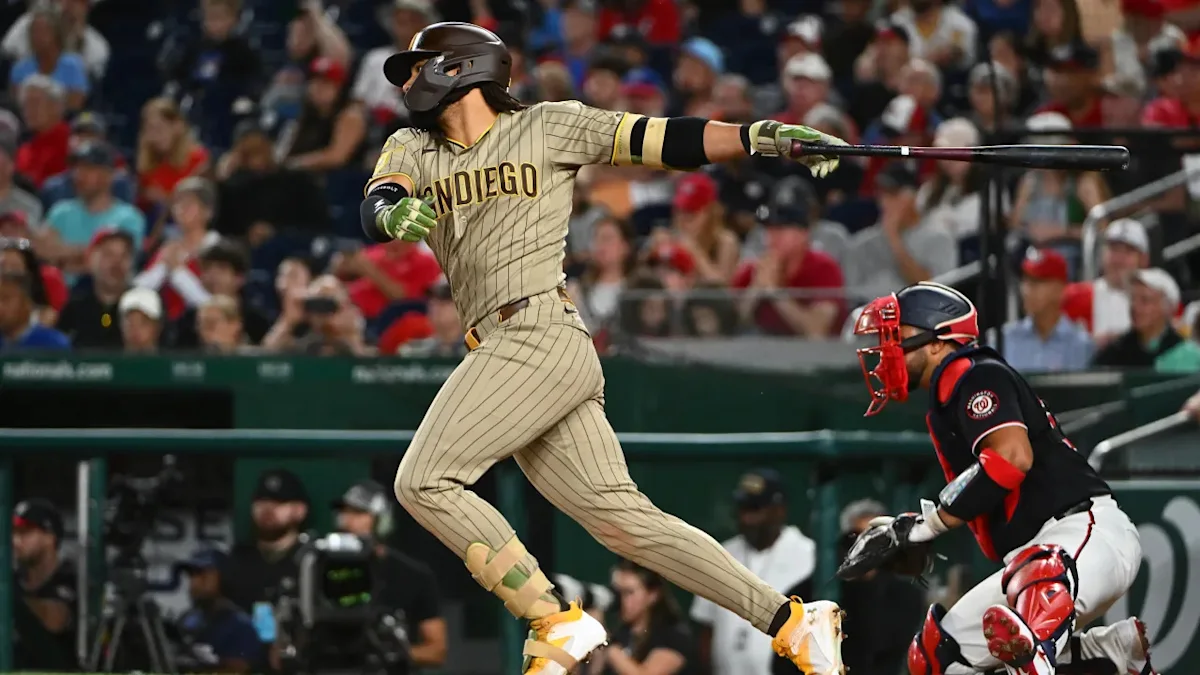 San Diego batter swings as a Washington catcher crouches behind home plate during a baseball game.