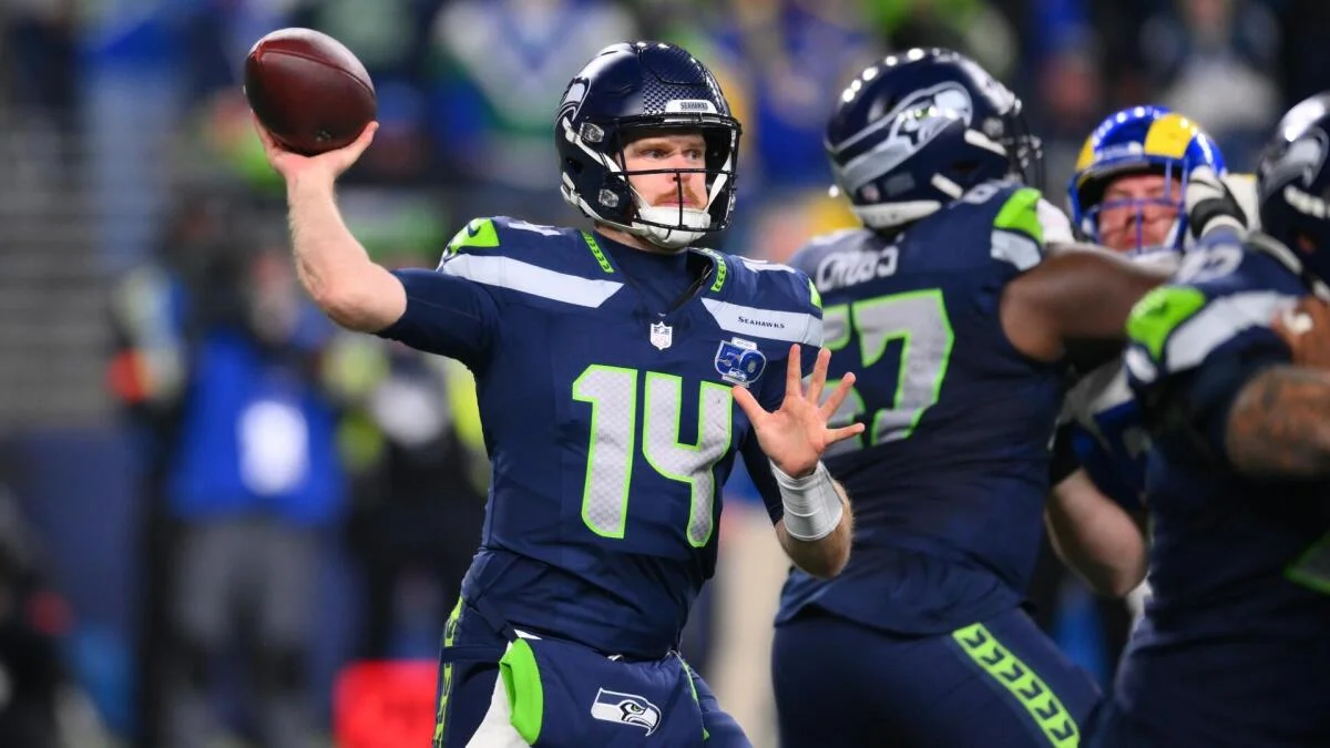 Seattle Seahawks quarterback in navy uniform throws a football during an NFL game