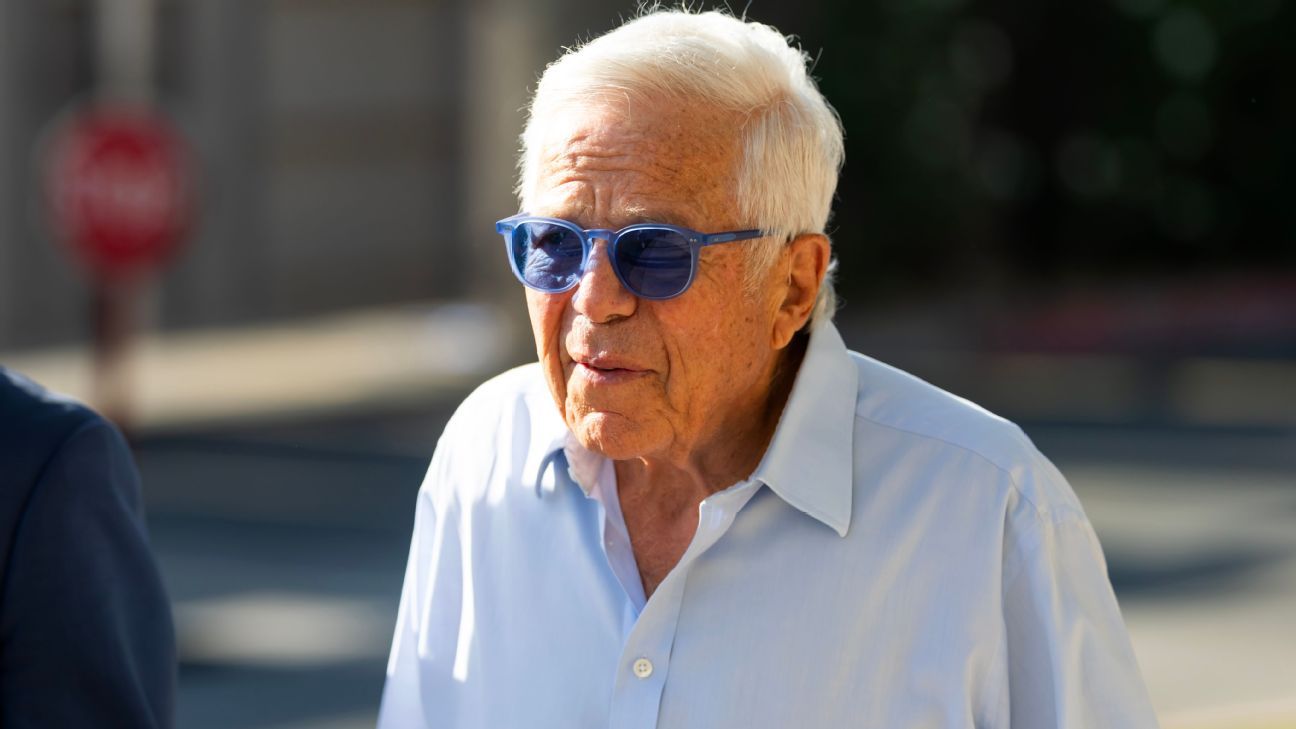 Elderly man wearing blue sunglasses and a white shirt outdoors in bright sunlight