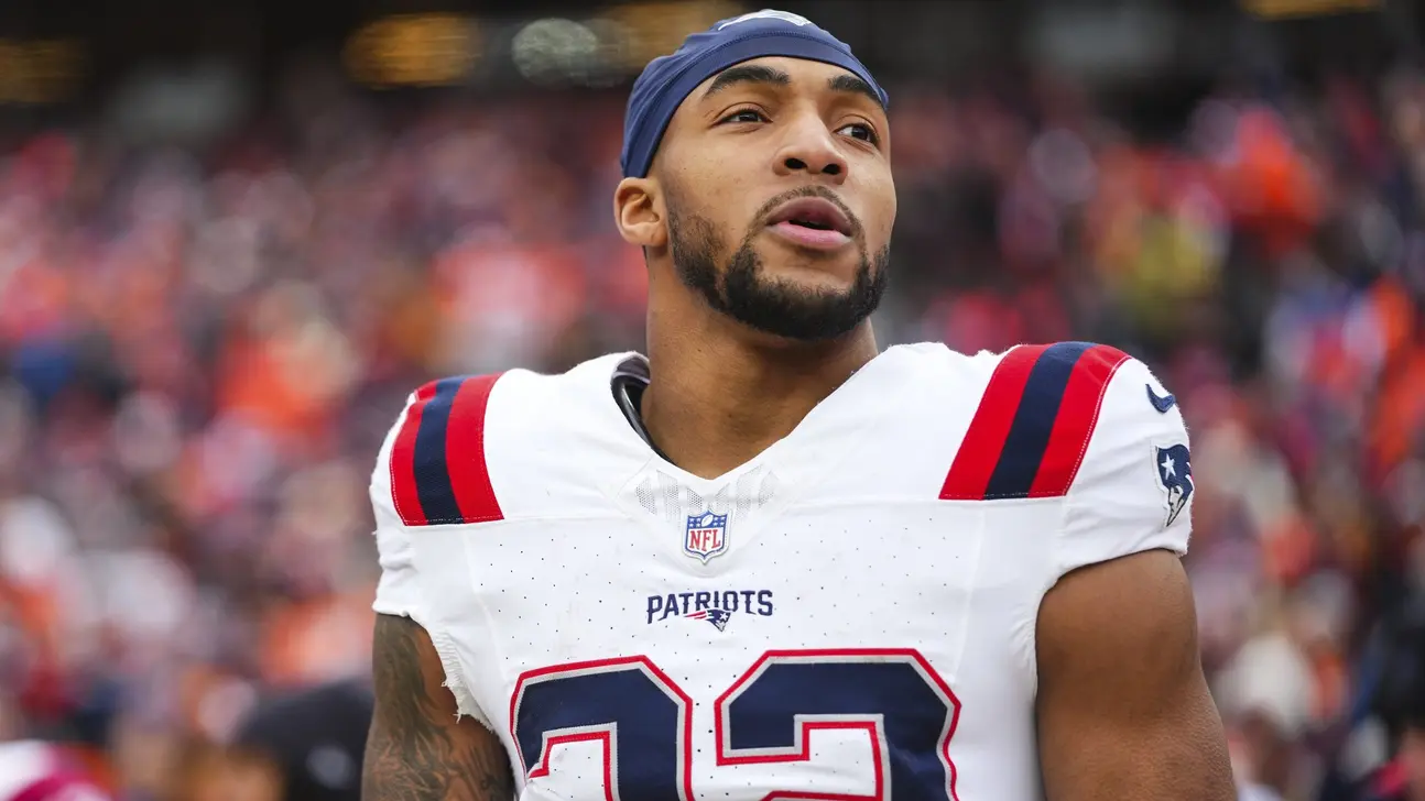 New England Patriots player wearing a white uniform and blue head covering on the field