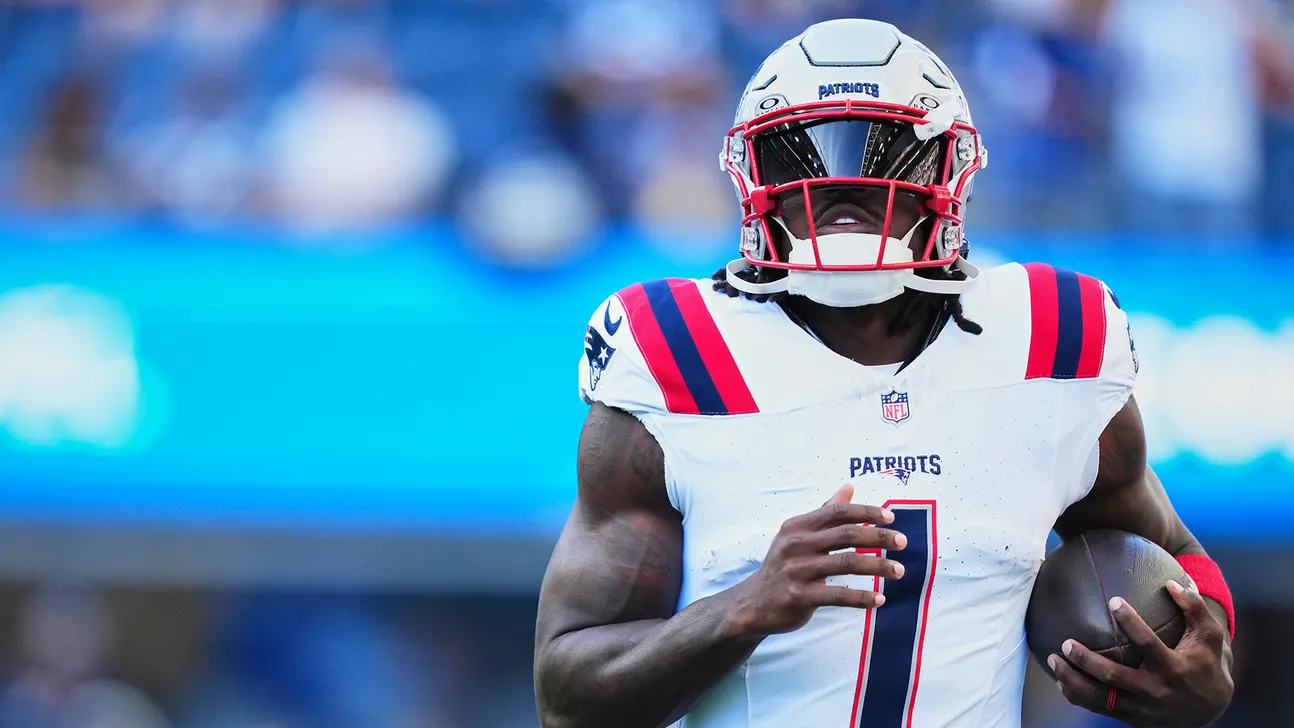 Patriots football player in white uniform and helmet carrying the ball