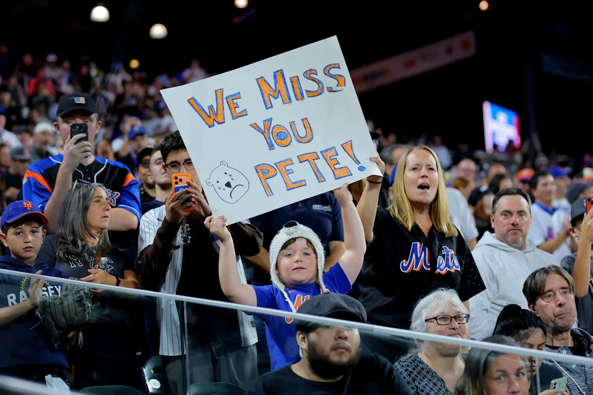 Mets fans hold a handwritten “We Miss You Pete!” sign above the crowd