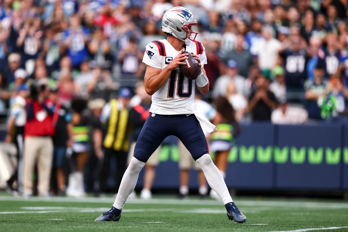 New England Patriots quarterback in uniform prepares to throw during a football game.
