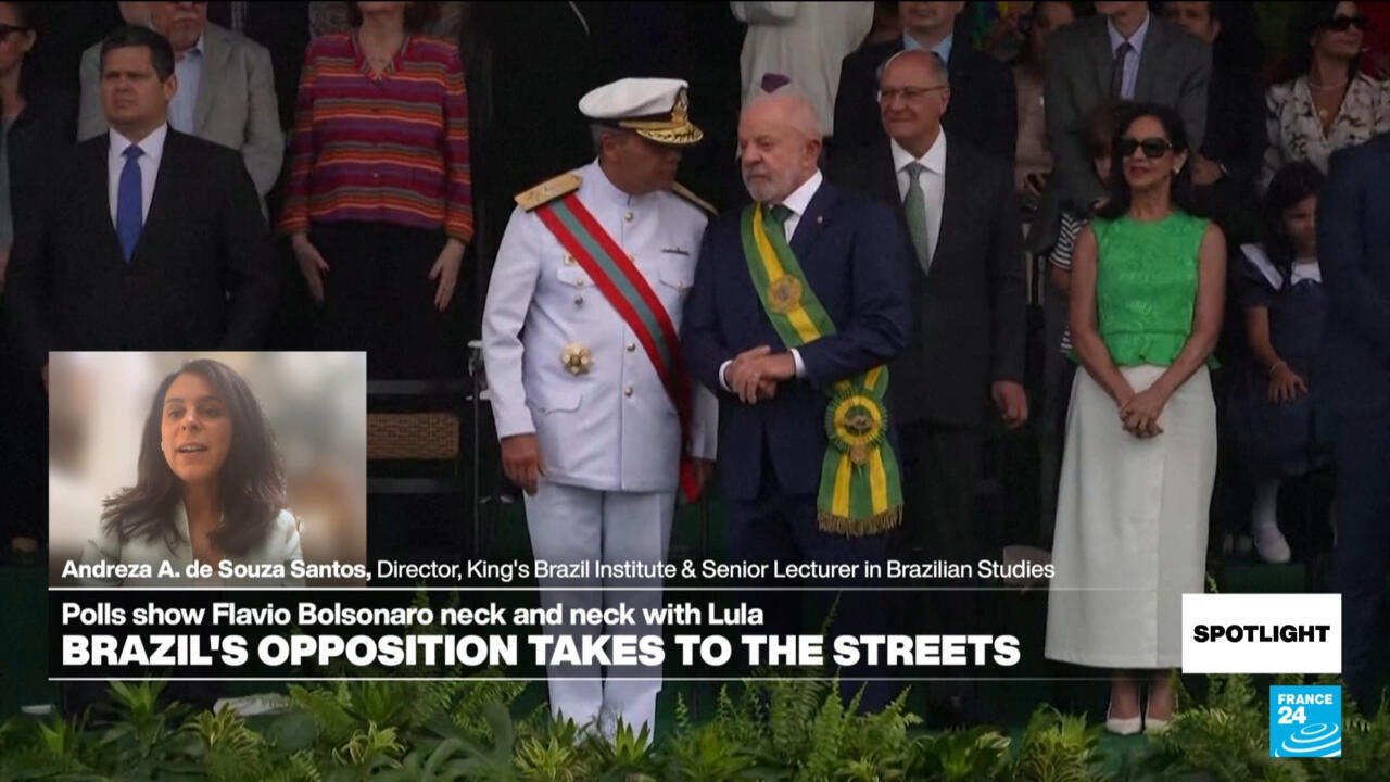 Brazilian officials stand on a balcony during a formal ceremony as spectators watch behind them.