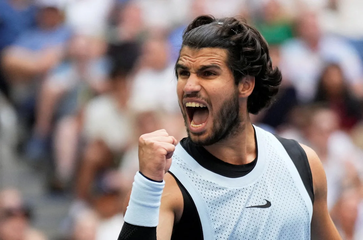 Tennis player shouting in celebration with a clenched fist during a match.
