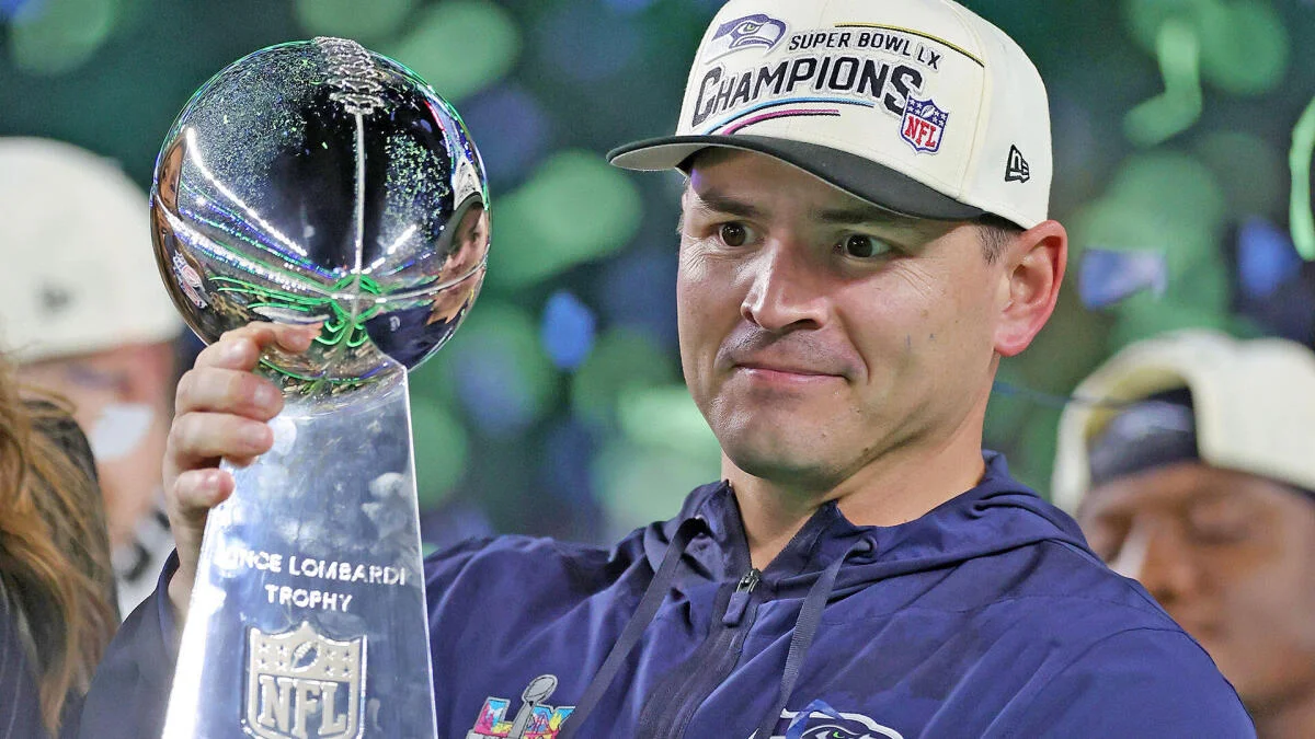 Seattle Seahawks player holds the Lombardi Trophy while wearing a Super Bowl champions cap