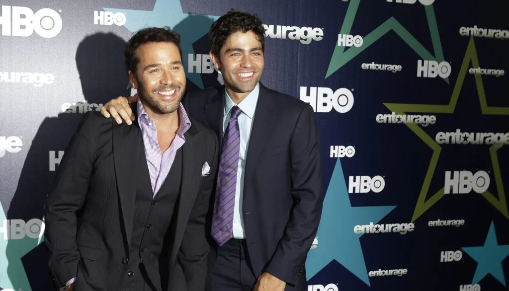 Two men in suits smile together at an HBO Entourage promotional event.
