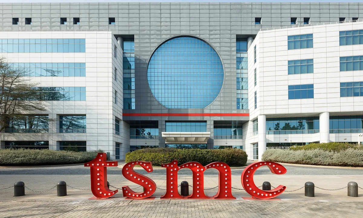 Modern TSMC office building with a large circular window and red illuminated logo outside