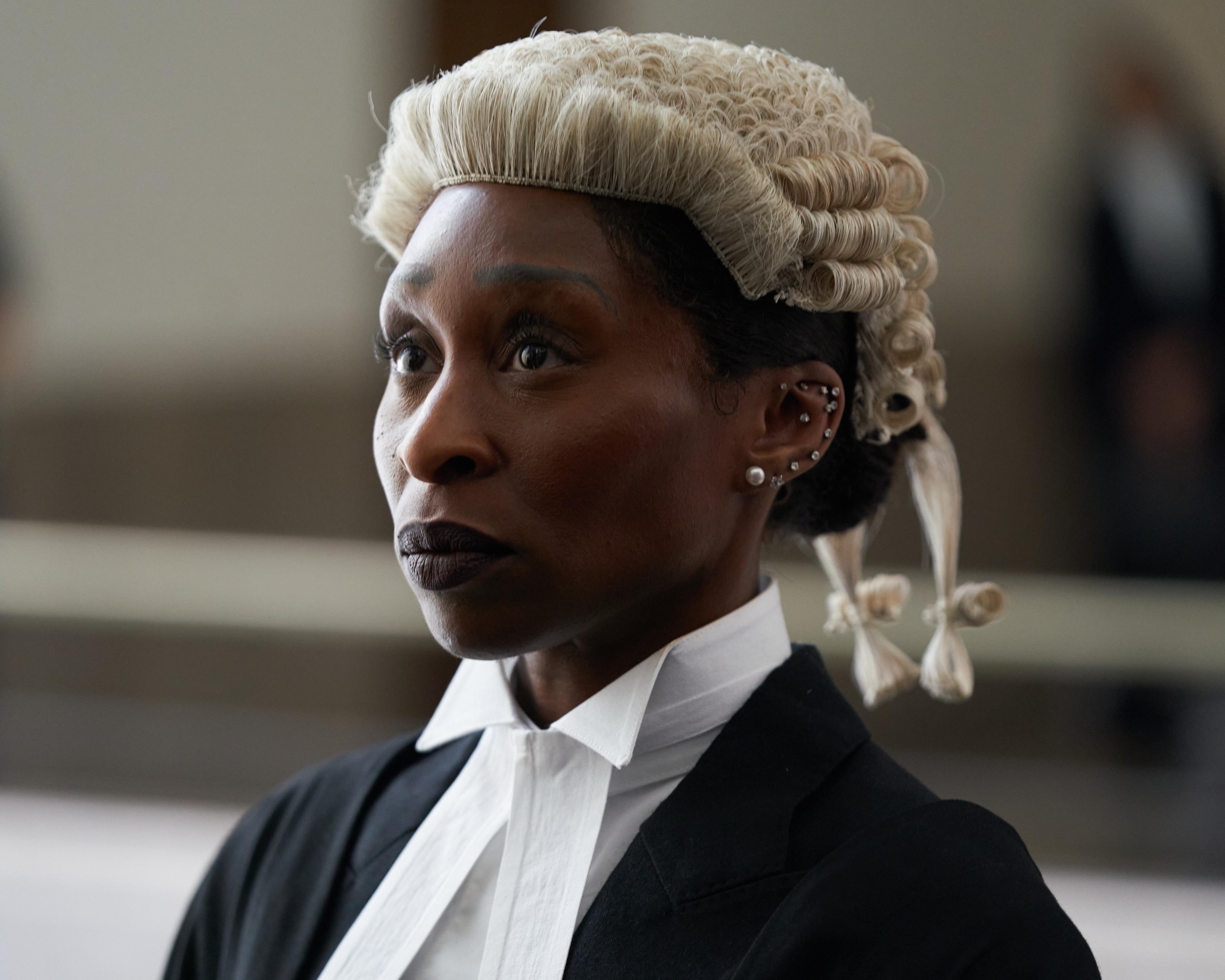 Black woman wearing a barrister’s wig and robes, looking to one side in close-up