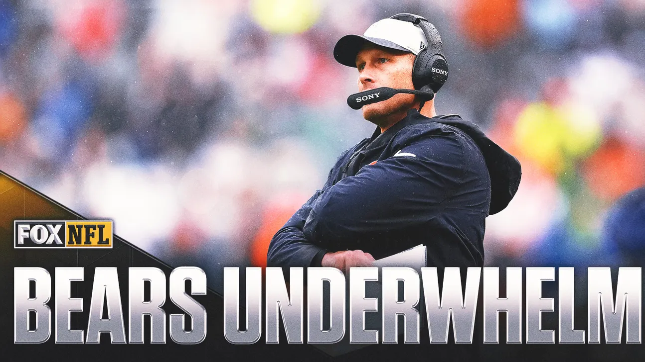 Football coach wearing headset and cap stands with arms crossed beside a FOX NFL graphic.
