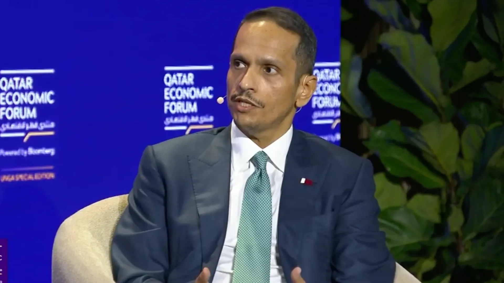 Man in suit speaking during a Qatar Economic Forum panel discussion
