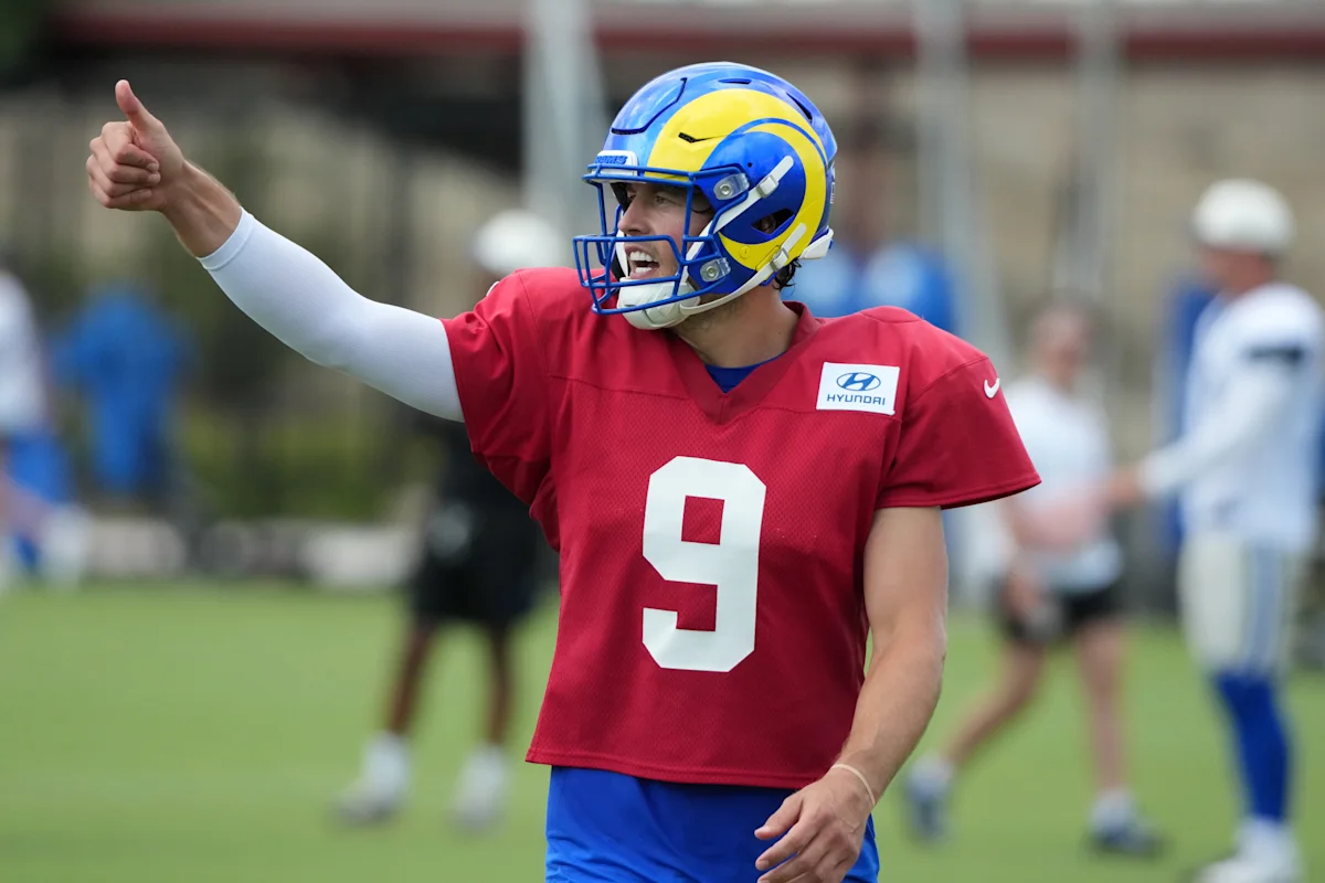 Football player in a Rams helmet and red jersey gives a thumbs-up during practice.