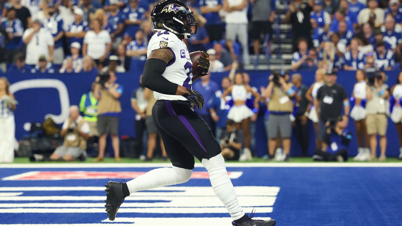 Baltimore Ravens player wearing number 22 runs with the football across the field