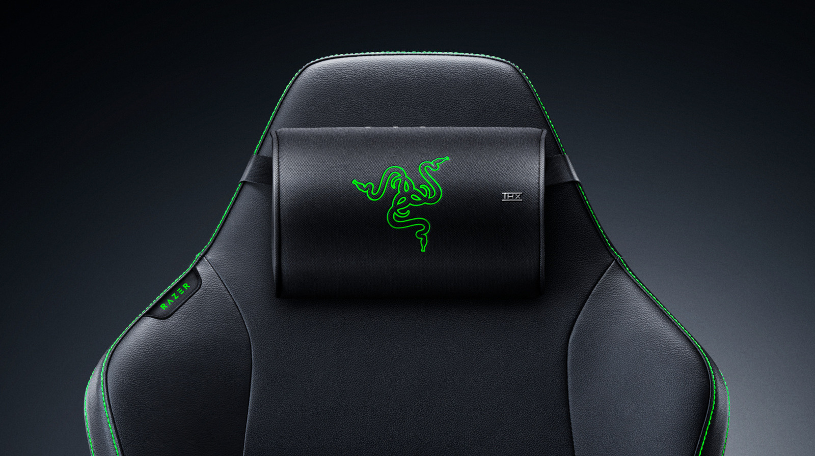 Black gaming chair with a rectangular head cushion featuring bright green Razer branding.