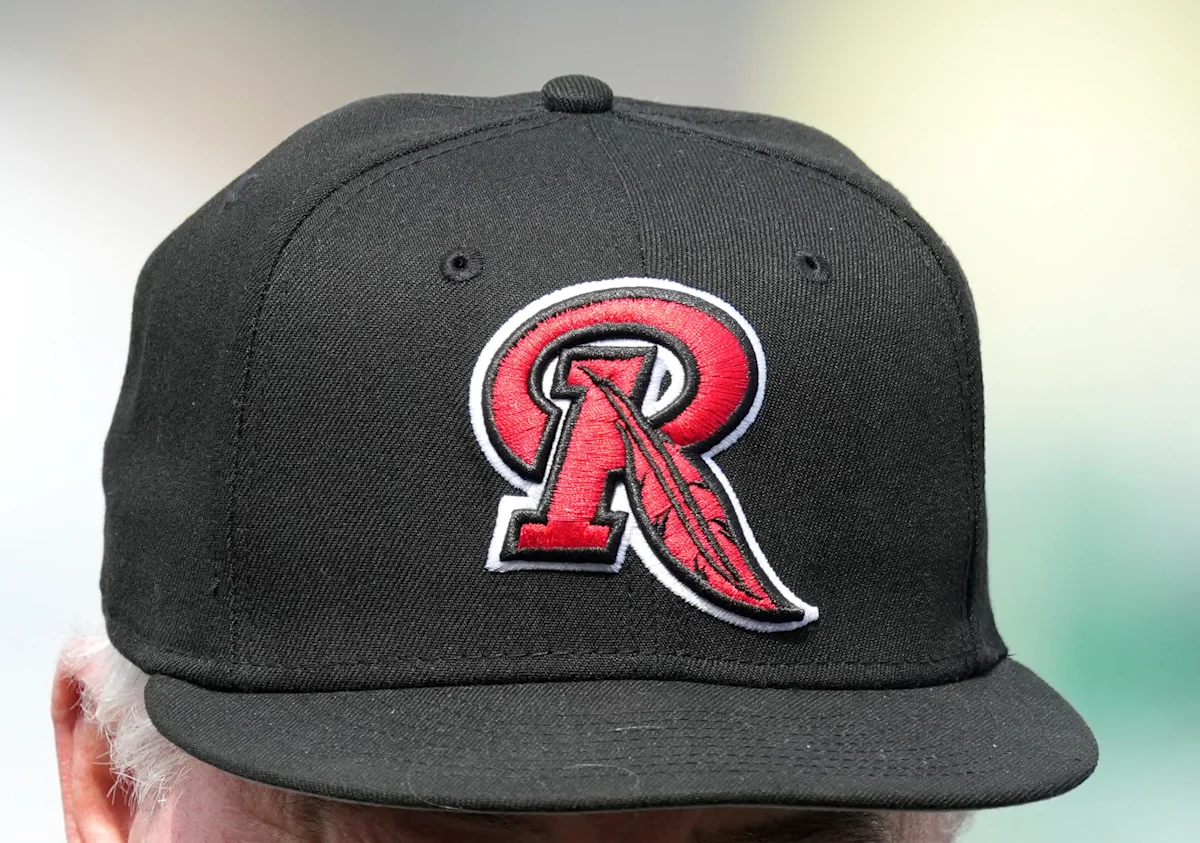 Black baseball cap featuring a red embroidered letter R and feather-like design