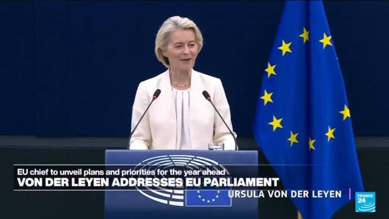 Woman speaking at a European Parliament podium beside European Union flags