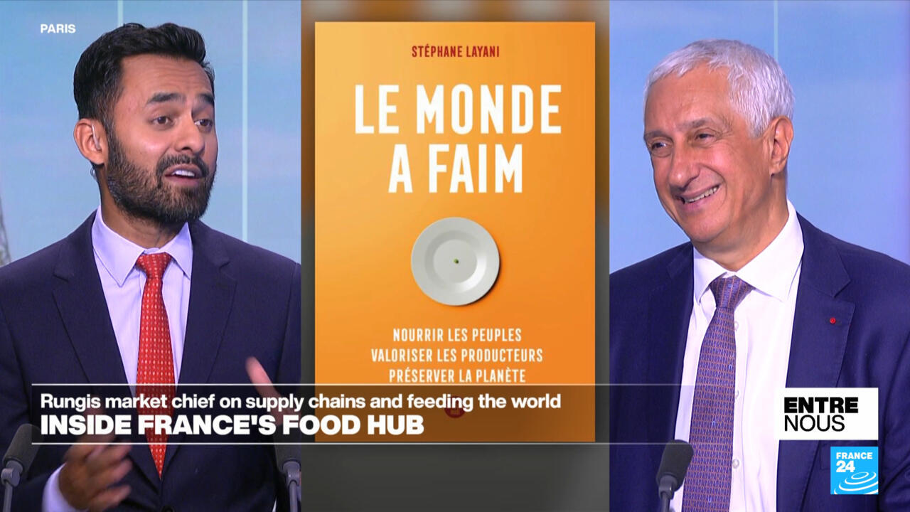 Split-screen television interview shows two suited men beside a French book cover about food and hunger.
