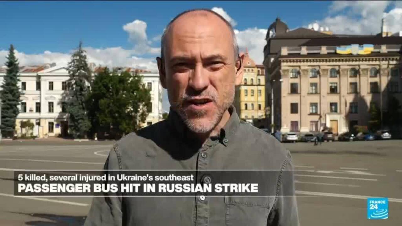 Man speaks to camera in a city square with news banner about a passenger bus strike.
