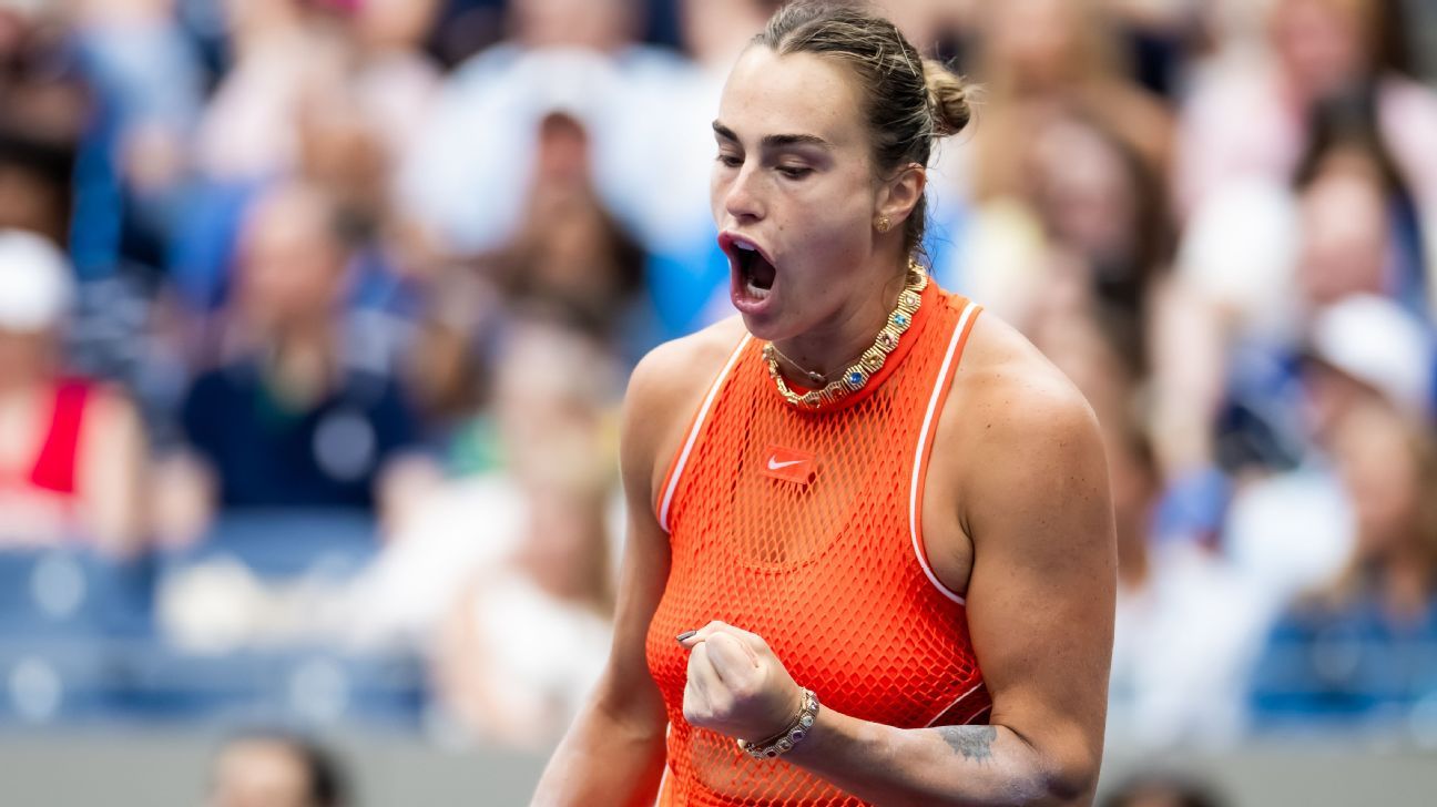 Tennis player in an orange top celebrates with a clenched fist during a match.