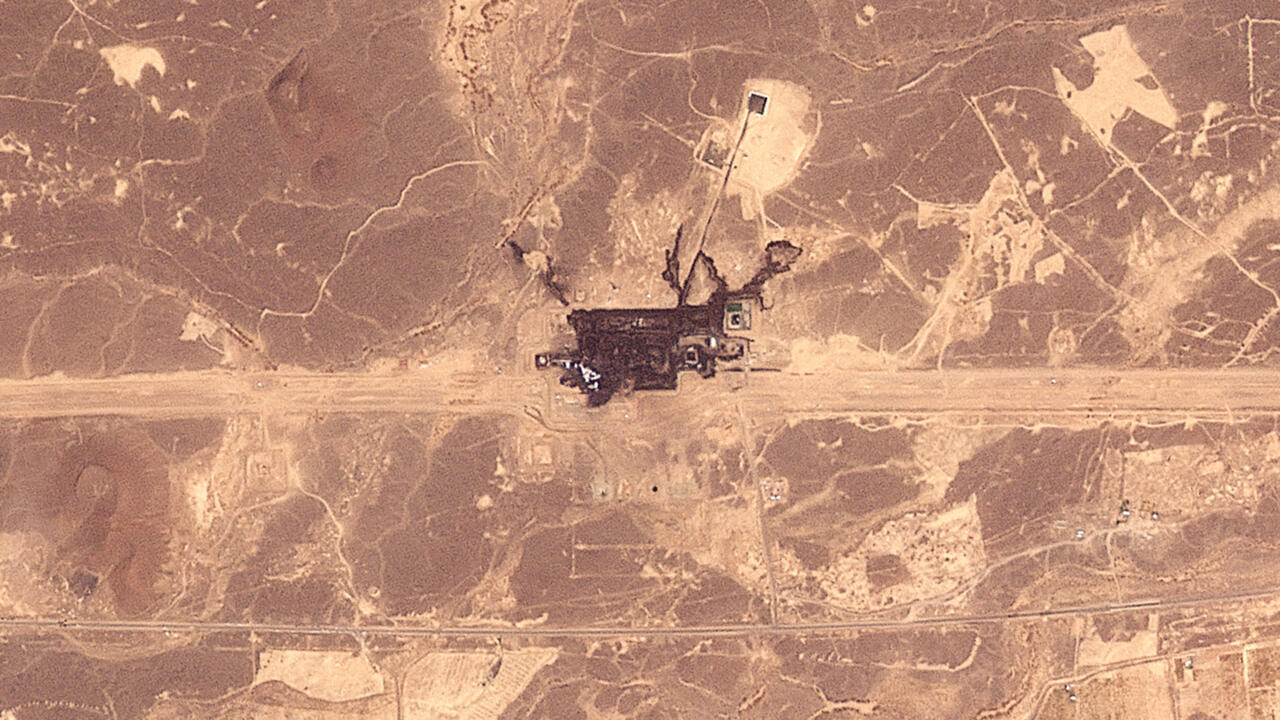 Aerial view of a large industrial facility amid desert tracks and surrounding earthworks