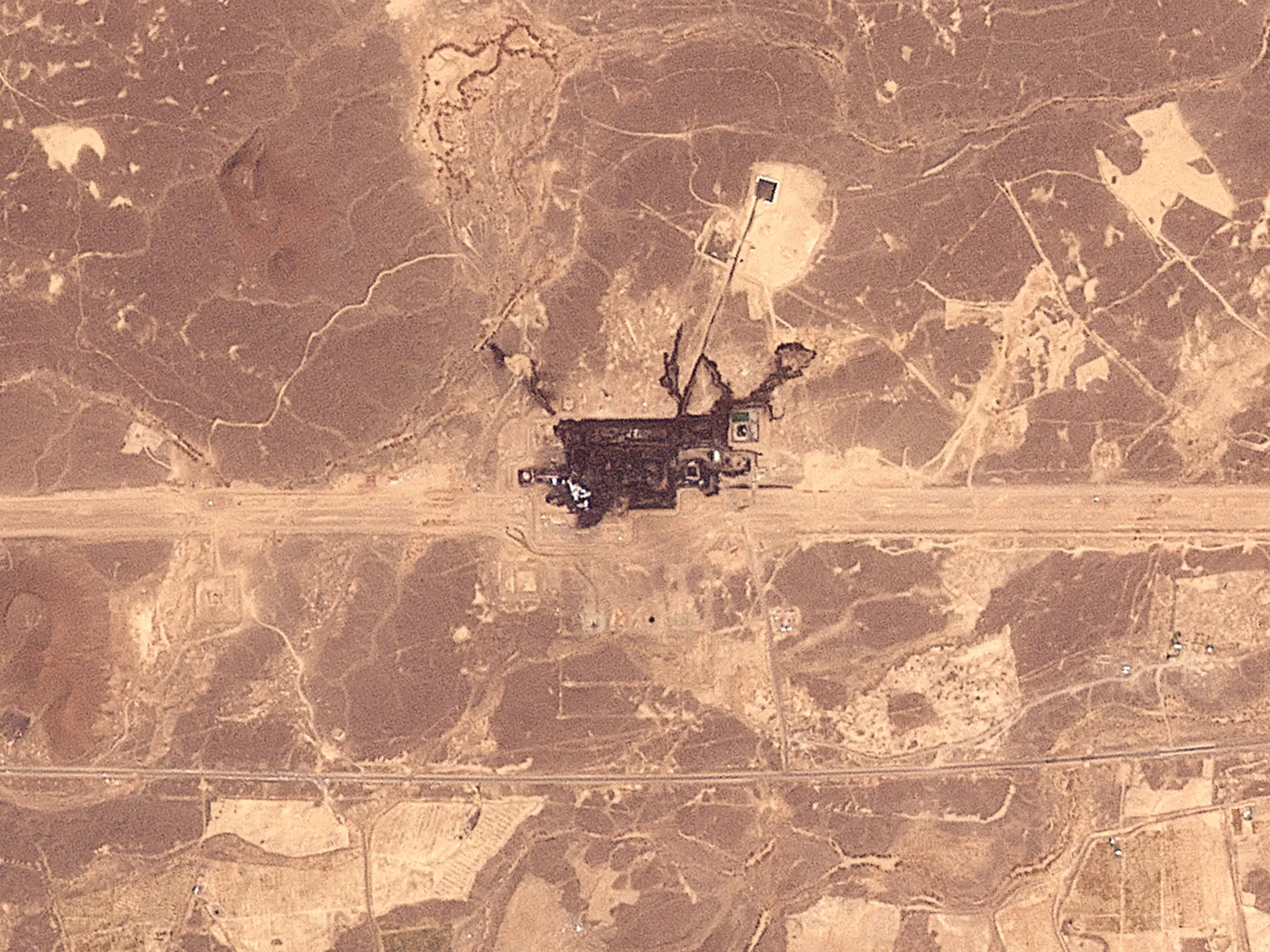Aerial view of an industrial installation amid roads and desert terrain