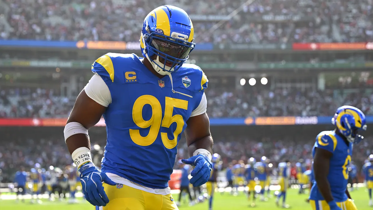 Football player wearing number 95 Rams uniform runs on field during a game