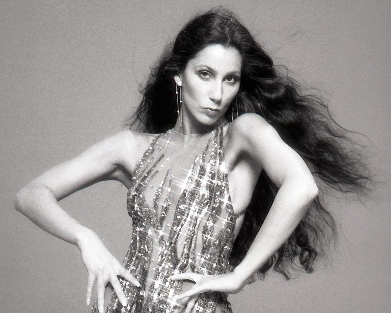 Black-and-white portrait of a woman with long dark hair wearing a sparkling sequined dress.