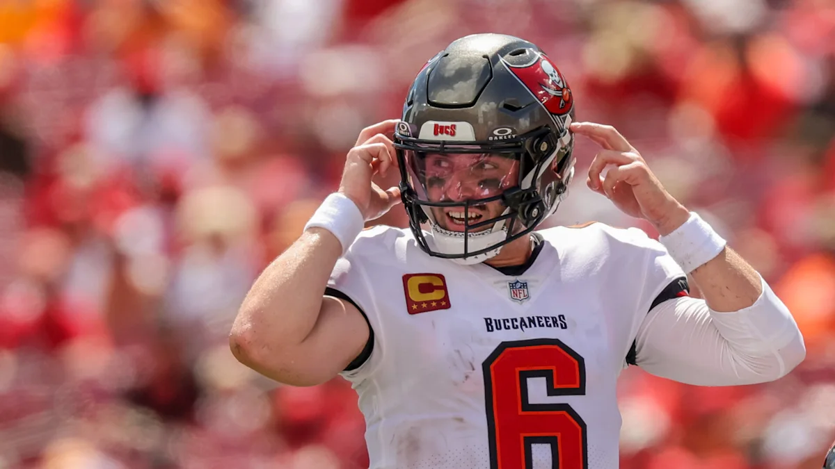 A Buccaneers player wearing number 6 adjusts his helmet on the field.