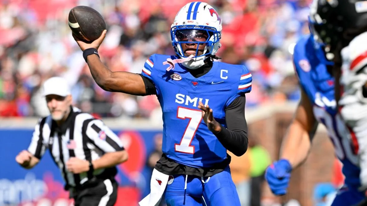 SMU quarterback in blue jersey throws a football during a college football game