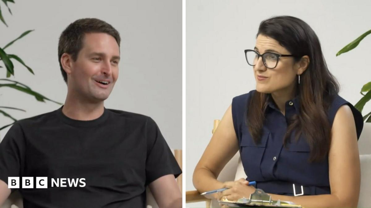 Split-screen interview showing a man in black and a woman wearing glasses seated indoors.