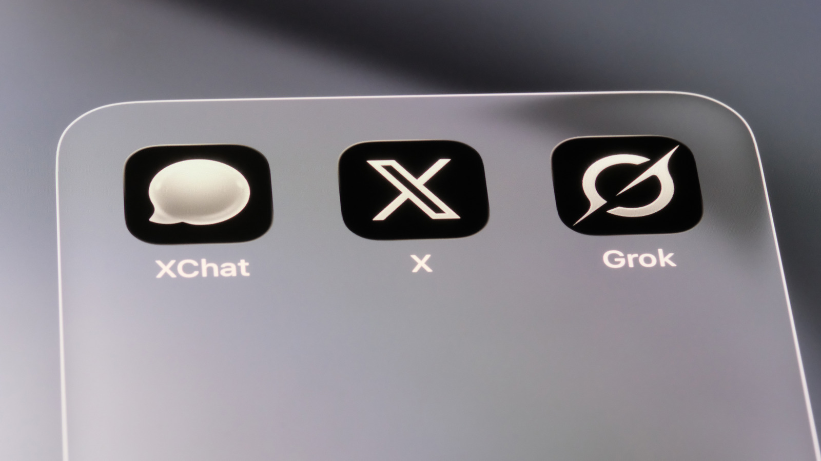 Screen showing XChat, X, and Grok app icons inside a rounded rectangular panel