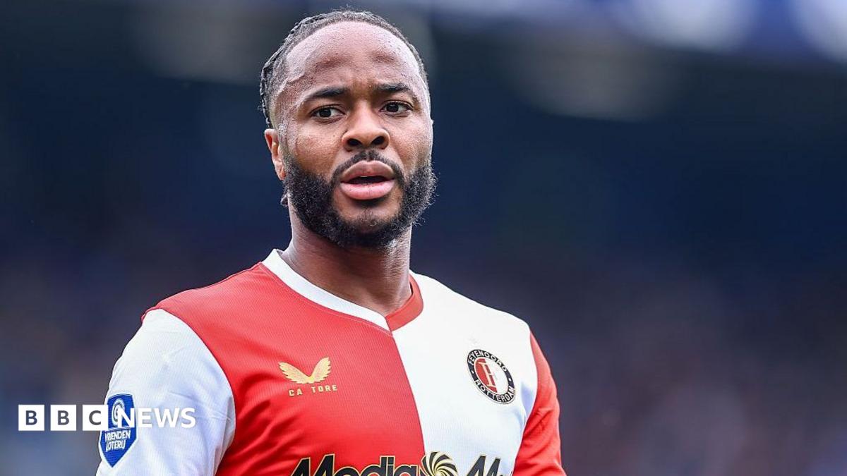 Footballer wearing a red and white Feyenoord shirt looks toward the camera during a match.