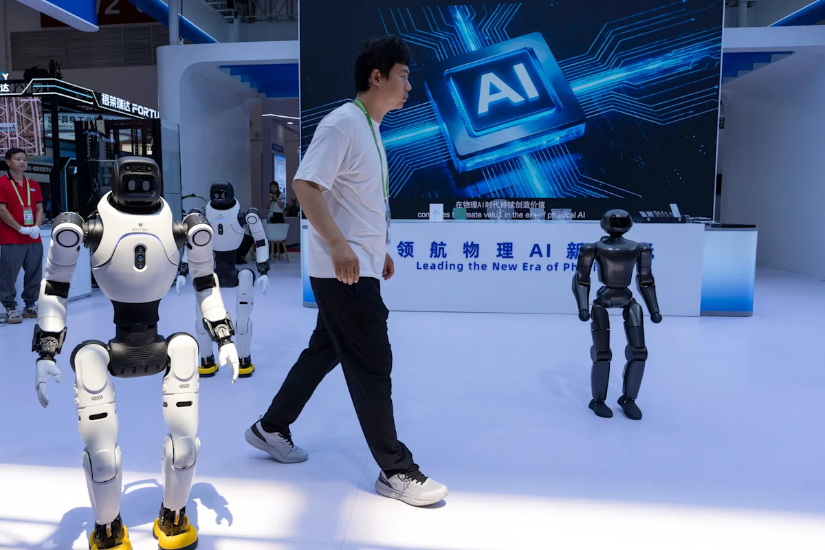 Humanoid robots and a man walk through an artificial intelligence technology exhibition.