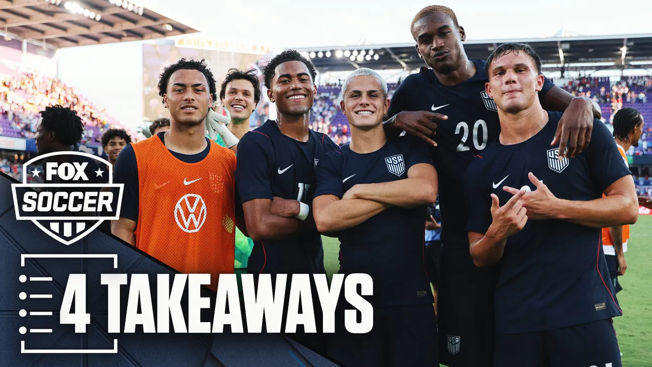 Young U.S. soccer players pose together on the field, with a goalkeeper in an orange training vest.