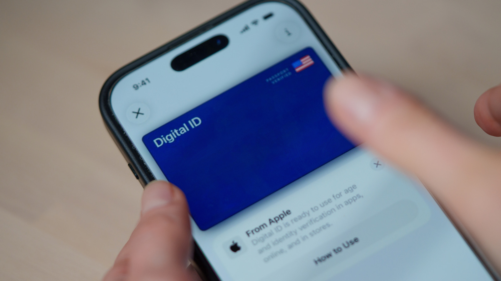 Close-up of a smartphone displaying a Digital ID card while held by someone's hands